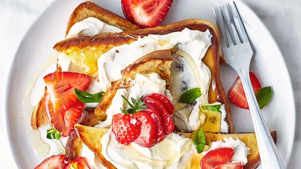 Dales color y sabor a estas torrijas con fresas frescas (o cualquier otro fruto rojo como arándanos o frambuesas), abundante queso ricotta, miel y menta. Puedes jugar con variaciones y sustituir el queso ricotta por requesón o queso cottage, ya que es la mezcla de queso fresco y untable con frutos rojos lo que hace a estas torrijas diferentes. Trozos de melocotón de temporada, bien maduro y, si tienes tiempo pasado por la sartén con un poco de mantequilla, también funcionan muy bien. La pizca de sal marina en el queso potenciará los sabores dulces.