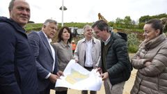 El alcalde de Sanxenxo, Telmo Martín, y la conselleira de Vivenda, María Martínez Allegue, en el centro, ven los planos de la parcela donde se levantarán 25 viviendas de promoción pública en Sanxenxo
