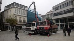 Un cami�n provisto de una gr�a hidr�ulica retira las vigas del interior del inmueble