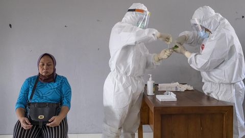 Trabajadores sanitarios realizan un test de coronavirus a una mujer en una ciudad india