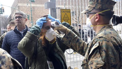 Un marine toma la temperatura a uno de los periodistas que se desplaz al muelle 90 para cubrir el atraque del USNS Comfort