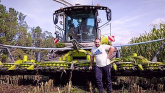 Jonathan Rodríguez, al pie de su cosechadora Claas 990, en un cultivo de maíz en Mazaricos.