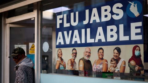 Un cartel anuncia vacunas contra la gripe en la ventana de una farmacia en Londres