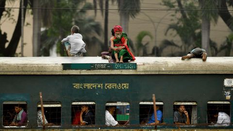 Pasajeros de Banglad�s viajan sobre el techo de un tren durante la celebraci�n de una prueba de golf en Dhaka (Banglad�s)