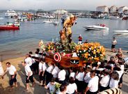 Los porteadores llevan la imagen hasta el puerto de O Grove para subirla a un barco. 