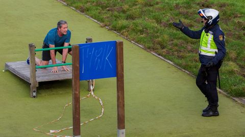  Un policia informa a un hombre de la prohibicion de hacer deporte en algunas zonas del parque de Invierno en Oviedo