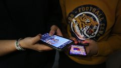 Dos adolescentes utilizando tel�fonos m�viles.