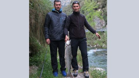 Dos pescadores sujeta el segundo salm�n del Cares, pescado en  el coto Niserias