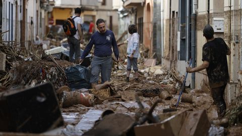 Varias personas se afanan en las labores de desescombre en Paiporta