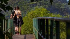 Una pareja observa el vallado de la peque�a osezna Villarina, que fue bautizada as� en recuerdo del pueblo donde fue rescatada, en la Senda del Oso, una v�a verde que discurre por los concejos de Proaza, Teverga, Quir�s y Santo Adriano