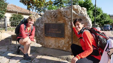 Elona y Nuria posan en Sahagn, en el punto que marca el ecuador de la ruta jacobea