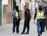 Dos agentes de la polic�a caminan y hablan con algunas personas durante el registro de la casa en Sevilla del presunto yihadista 