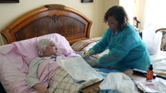 Chus Llorente atiende a Aurora, paciente crnica afectada por la enfermedad de Crohn y hospitalizada en su propio domicilio