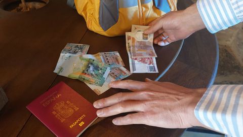 Mostrando el pasaporte y moneda kuwait&iacute;