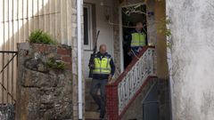 Una agente sale del domicilio con el rifle de balines con mira telesc�pica incautado.