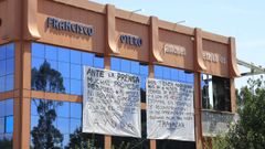 La fachada de Gourmet Otero presenta dos grandes pancartas de protesta.