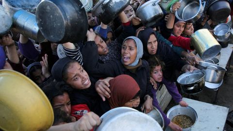 Palestinos esperando recibir comida procedente de la ayuda humanitaria
