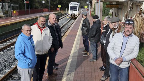 Varios usuarios del ferrocarril de ancho métrico, indignados por el declive de la línea, ayer en la estación de San Sadurniños