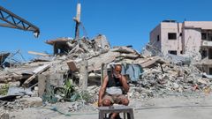 Un hombre liban�s fuma un cigarrillo delante de un edificio en ruinas.