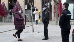 Dos polic�as vigilan en Monforte el cumplimiento de las restricciones contra el covid-19, junto a la terraza de un bar que da caf�s para llevar