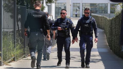 Polic�as griegos�caminan frente al Tribunal de Apelaci�n de Atenas tras�el tiroteo que dej� varios heridos.