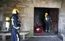 Los Bomberos accediendo al santuario tras cortar una de sus puertas con una motosierra. 