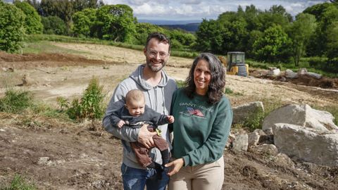 Chris, Paula y su segundo hijo frente al terreno de Bante donde estn construyendo su casa