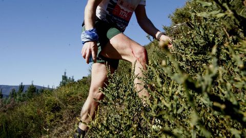 Uno de los corredores sube el monte de Vila��n con ara�azos en las piernas