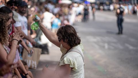 Una mujer con un dispensador de agua, espera la llegada del papa