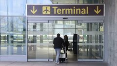 Dos personas entrando en la terminal de Alvedro