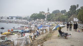 Inmigrantes hacinados en una playa del puerto de Ceuta.