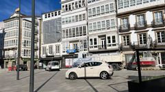 Coches circulando sobre el pavimento de la plaza de la Constituci�n por la ocupaci�n con maquinaria de la calle de la Iglesia, que desv�a el acceso al p�rking.