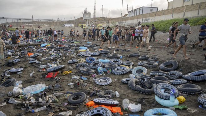Flotadores y migrantes tras traspasar la frontera entre Ceuta y Marruecos