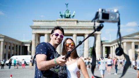Una pareja de turistas se hace un selfie cerca de la puerta de Brandenburgo, en Berl�n.