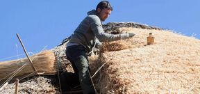Uno de los teitadores coloca paja nueva en la palloza de Gal�n, que es la que est� da�ada por los descensos en trineo. 