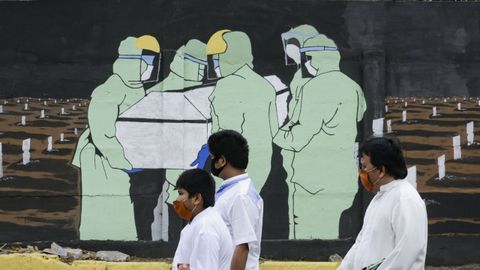 Viandantes, con mascarilla en una calle de Yakarta