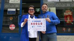 Estrella Castrill�n, una de las propietarias de esta administraci�n, posa con el n�mero premiado junto a su hijo, �scar, que atiende en la ventanilla del establecimiento.