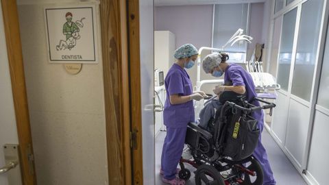 Noelia Ferreiro y Aldara Alonso realizando un tratamiento de flúor a un pequeño con discapacidad.