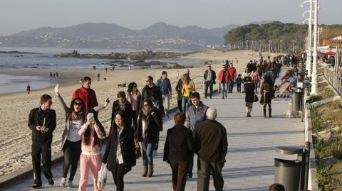 Paseantes en la playa de Samil.