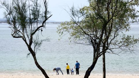 Una familia disfruta de un da de buen tiempo en la playa de Barraa (Boiro).