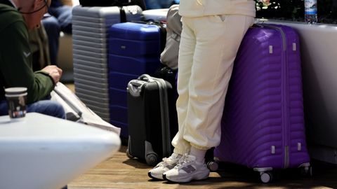 Un pasajero espera con su maleta el embarque de un vuelo en el aeropuerto de Fr�ncfort.