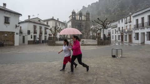 Dos vecinas de Grazalema, en C�diz, corren por una calle inundada