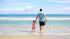 Un padre, disfrutando con su hija de un d�a de descanso en la playa