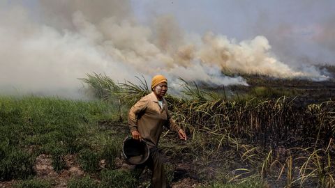 Una vecina trata de extinguir el fuego en Ogan Ilir, cerca de Palembang, en el sur de Sumatra