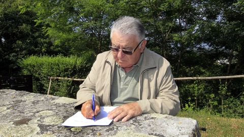 Manuel Lourenzo escribindo a man, nunha imaxe do 2016