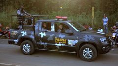  Un veh�culo de la polic�a patrulla cerca de familaires y allegados de los presos de la c�rcel de la ciudad de Altamira este lunes, en el estado de Par� (Brasil)