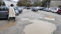 Grandes baches llenos de barro llenan las zonas de paso del aparcamiento de tierra del S�nchez Aguilera.