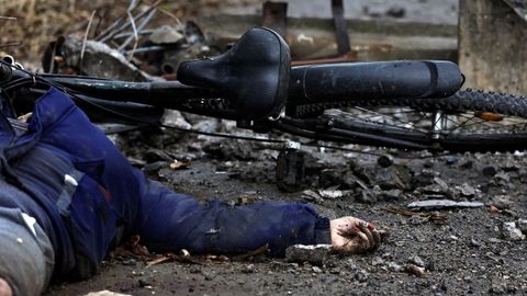 Una mujer, entre la veintena de cuerpos que yacen en una calle de la localidad de Bucha, en la periferia de Kiev.