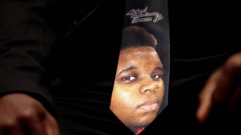 Un hombre lleva puesta una corbata con la cara de Michael Brown durante el funeral del joven abatido por la polic�a