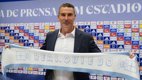 El nuevo entrenador del Oviedo, Luis Carri�n, posa con una bufanda del club durante su presentaci�n oficial